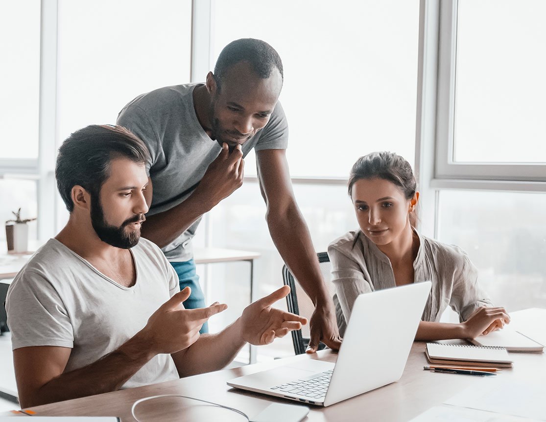 People discussing a project around a laptop